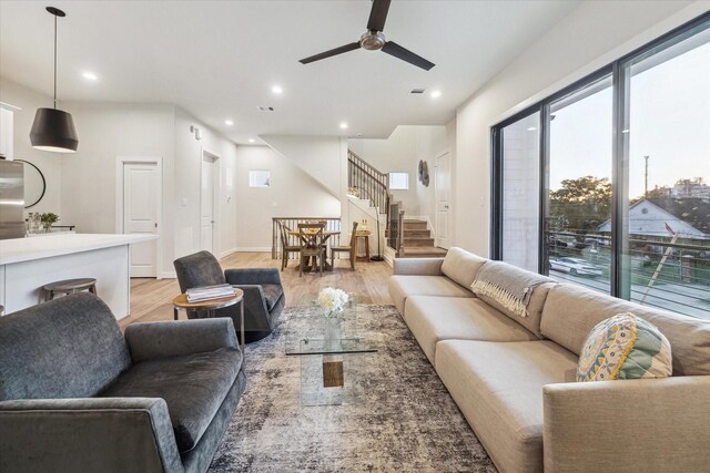 living room featuring light hardwood / wood-style flooring and ceiling fan