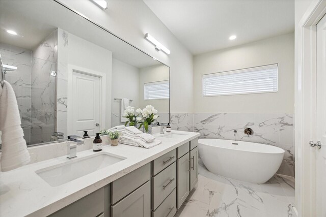 bathroom with vanity, tile walls, and shower with separate bathtub