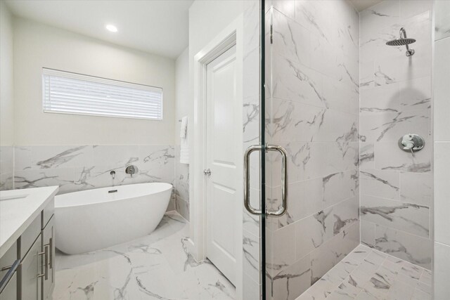 bathroom featuring shower with separate bathtub, vanity, and tile walls