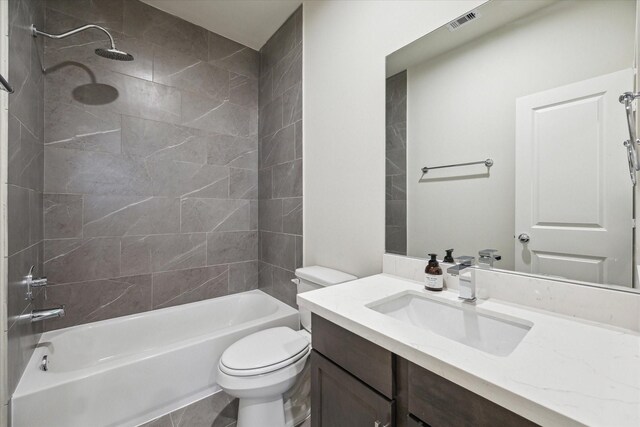 full bathroom with vanity, tiled shower / bath combo, toilet, and tile patterned flooring