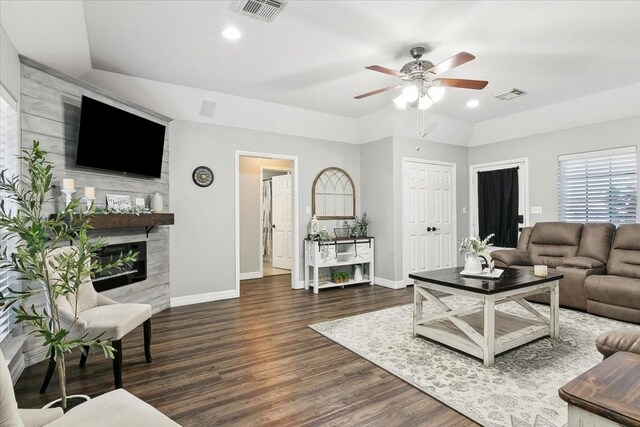 living room featuring a large fireplace, dark hardwood / wood-style floors, and ceiling fan