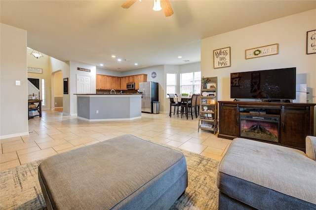 living room with sink, ceiling fan, and light tile patterned flooring