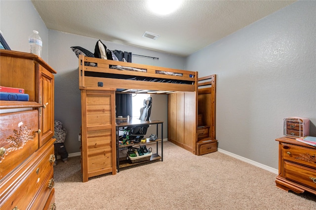 carpeted bedroom featuring a textured ceiling