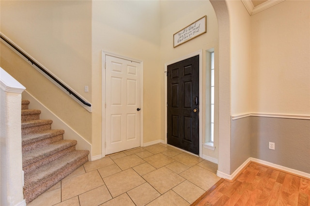 tiled foyer featuring ornamental molding