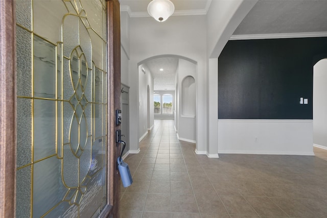 tiled foyer entrance with crown molding