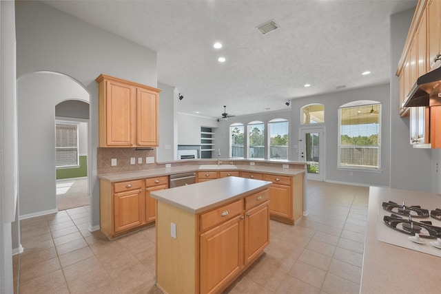 kitchen with dishwasher, a center island, kitchen peninsula, sink, and light brown cabinetry