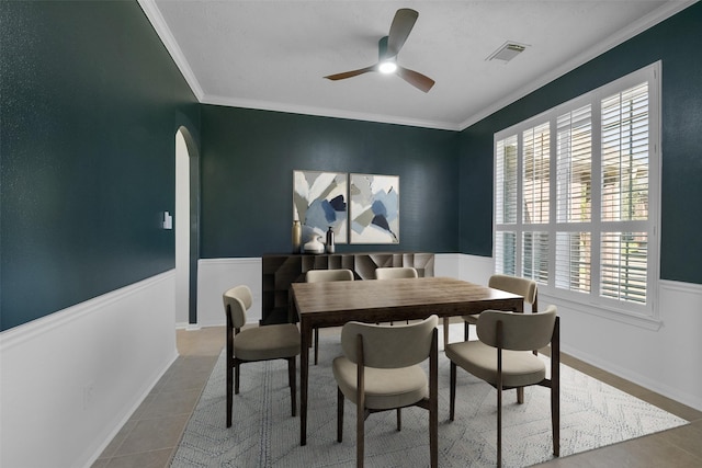 tiled dining area featuring ceiling fan and crown molding