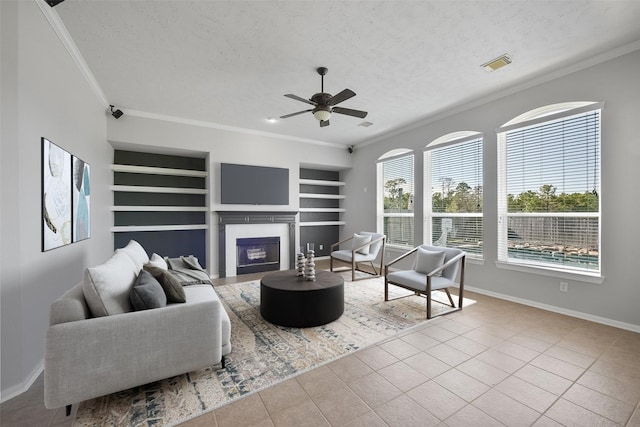 living room featuring a textured ceiling, built in features, ornamental molding, light tile patterned flooring, and ceiling fan