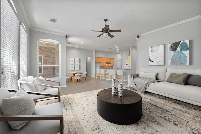 living room featuring ceiling fan and crown molding