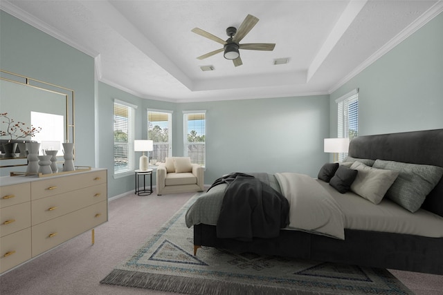 carpeted bedroom featuring ceiling fan, a tray ceiling, and crown molding