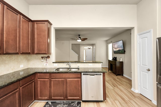 kitchen featuring ceiling fan, dishwasher, sink, kitchen peninsula, and dark stone counters