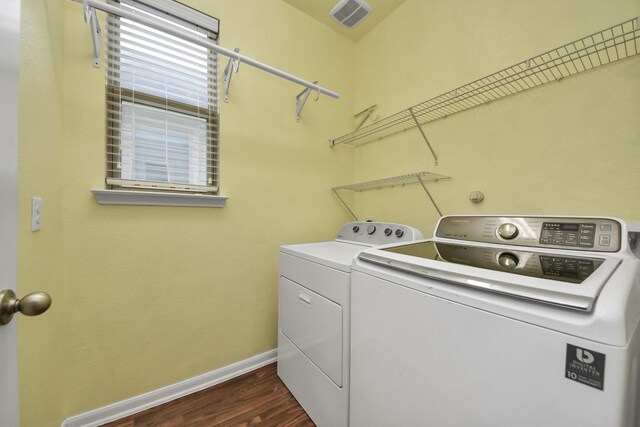 clothes washing area with dark hardwood / wood-style floors and washing machine and clothes dryer