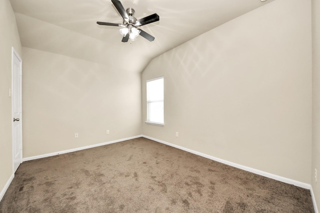 carpeted spare room with vaulted ceiling and ceiling fan