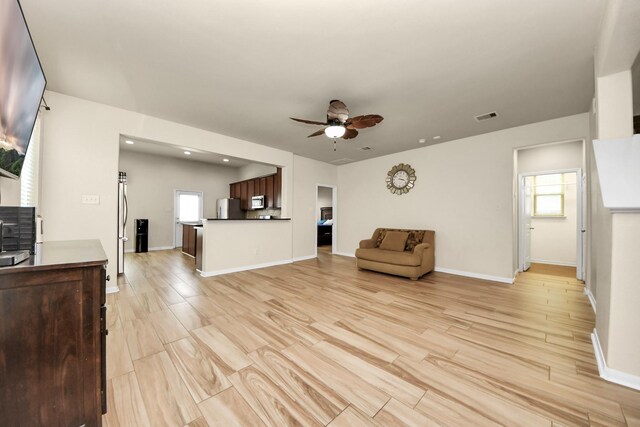 living room featuring light hardwood / wood-style floors and ceiling fan