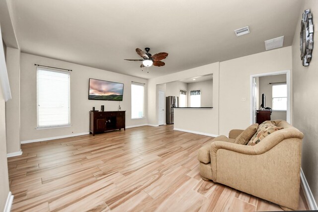 living room featuring light hardwood / wood-style flooring and ceiling fan