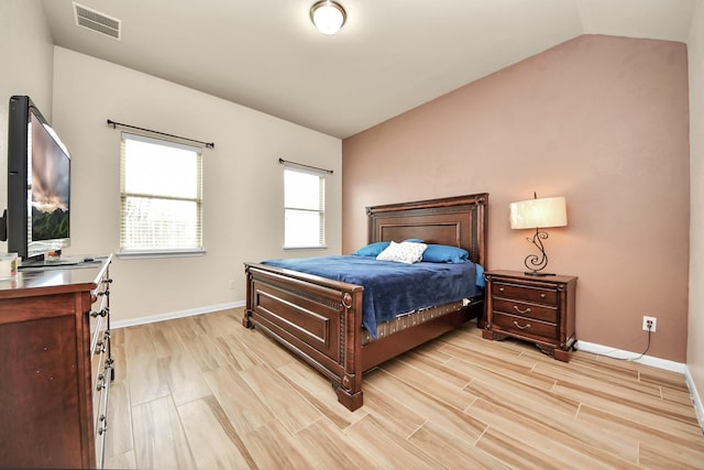 bedroom featuring light wood-type flooring and vaulted ceiling