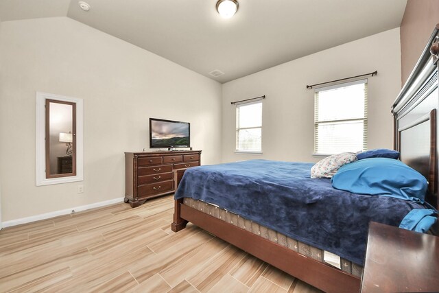 bedroom featuring light hardwood / wood-style flooring and lofted ceiling