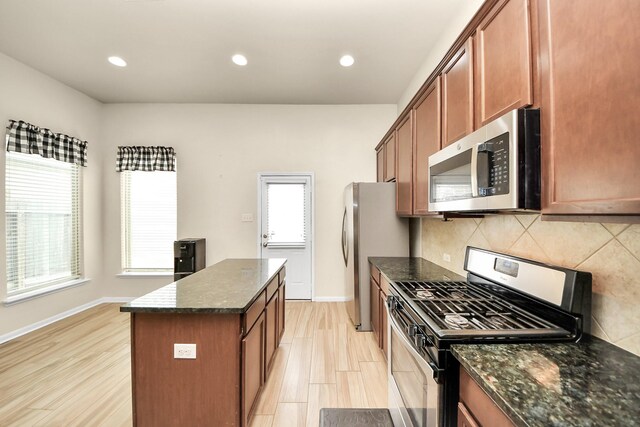 kitchen featuring plenty of natural light, a kitchen island, backsplash, and appliances with stainless steel finishes