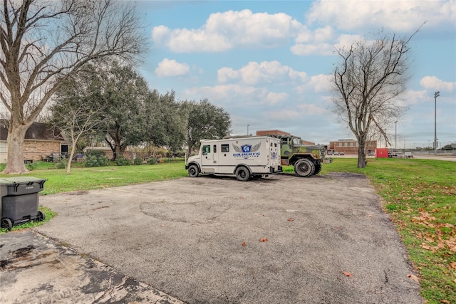 view of vehicle parking featuring a lawn