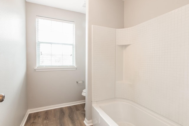 bathroom with shower / bath combination, toilet, and wood-type flooring