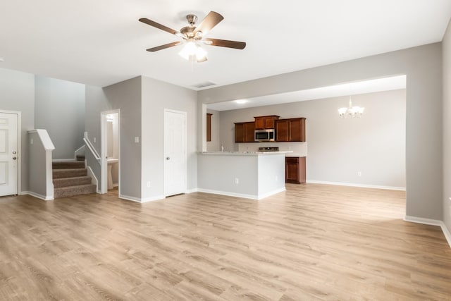 unfurnished living room with light hardwood / wood-style flooring and ceiling fan with notable chandelier