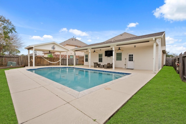 view of pool with a lawn, a patio area, and ceiling fan