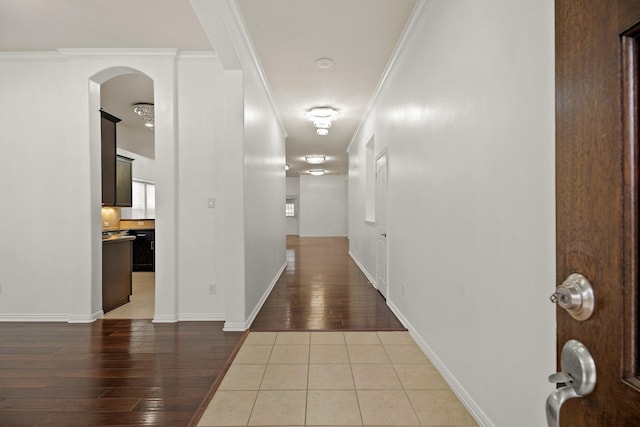 corridor with hardwood / wood-style flooring and ornamental molding