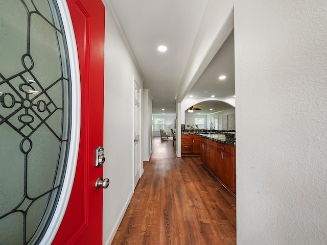 corridor featuring dark hardwood / wood-style floors and crown molding