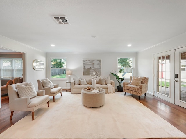 living room featuring french doors, light hardwood / wood-style floors, and ornamental molding