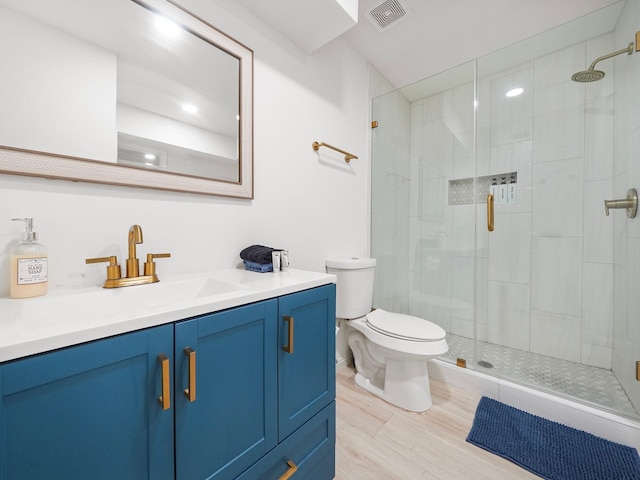 bathroom featuring hardwood / wood-style floors, vanity, toilet, and a shower with door