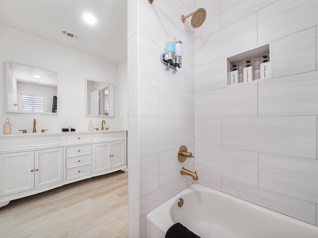 bathroom with vanity and tiled shower / bath combo