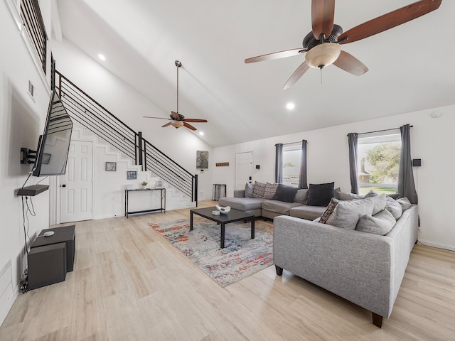 living room with light wood-type flooring, high vaulted ceiling, and ceiling fan