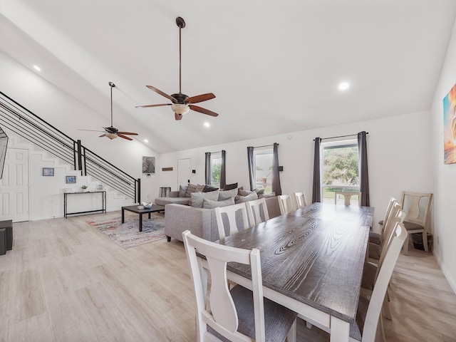 dining room featuring light hardwood / wood-style floors, high vaulted ceiling, and ceiling fan