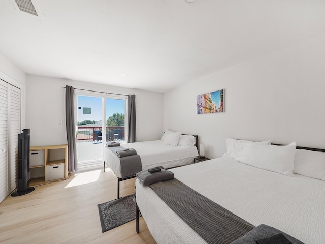 bedroom with access to exterior and light hardwood / wood-style flooring