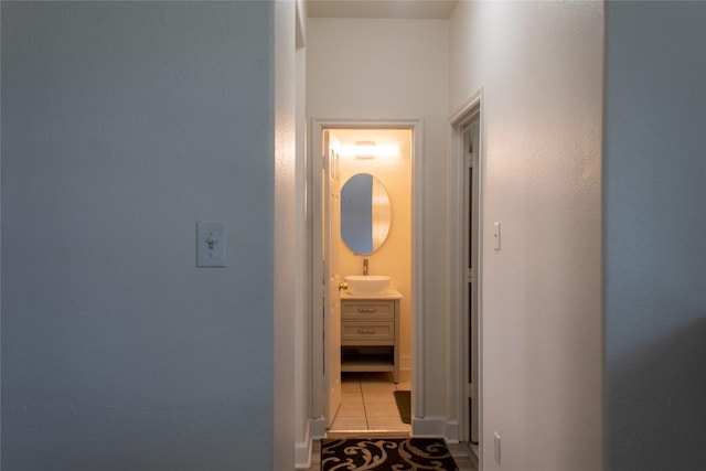 hallway with light tile patterned floors and sink