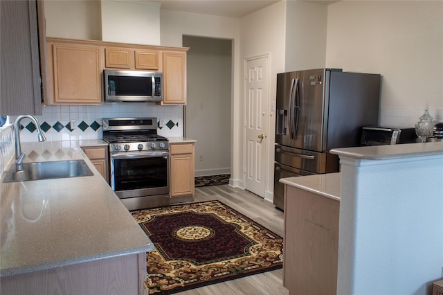 kitchen with light hardwood / wood-style floors, sink, stainless steel appliances, and light brown cabinets