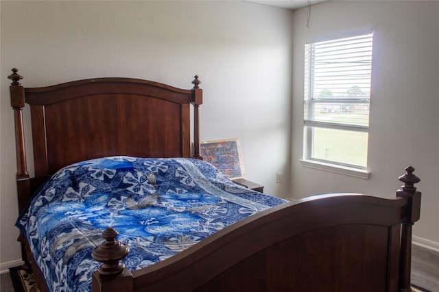 bedroom with hardwood / wood-style flooring and multiple windows