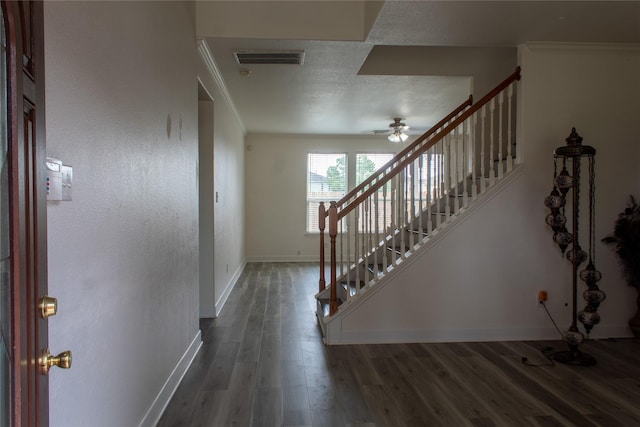 foyer entrance featuring ceiling fan, crown molding, and dark wood-type flooring