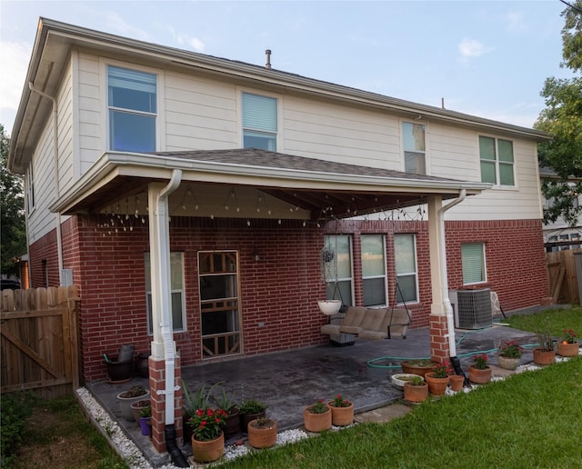 rear view of house featuring central AC unit and a patio area