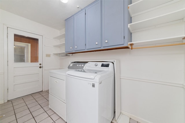 laundry room with cabinets, light tile patterned floors, and washer and dryer