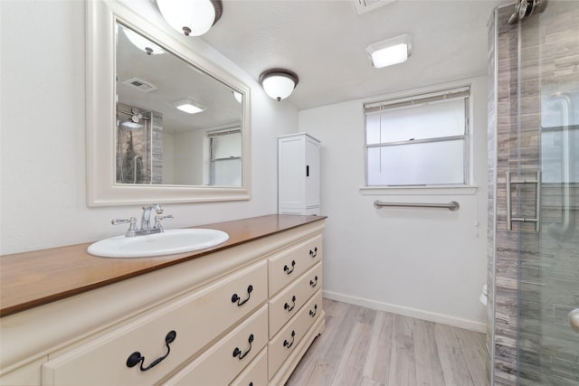 bathroom featuring wood-type flooring, vanity, and an enclosed shower