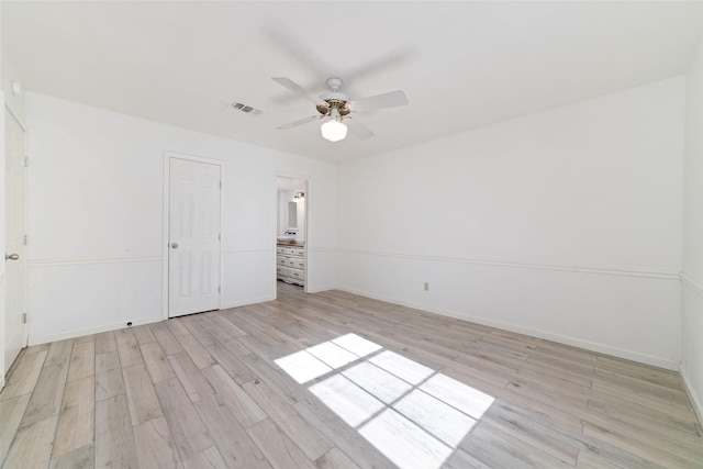 unfurnished bedroom featuring ceiling fan, light hardwood / wood-style floors, ensuite bathroom, and a closet