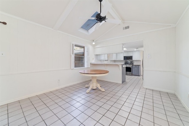 kitchen with appliances with stainless steel finishes, ceiling fan, white cabinets, a breakfast bar area, and light tile patterned flooring