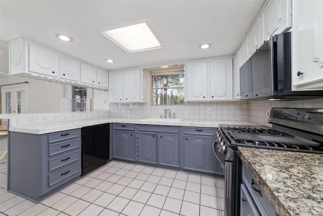 kitchen featuring kitchen peninsula, white cabinetry, sink, and appliances with stainless steel finishes