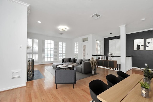 living room with crown molding, wood finished floors, baseboards, visible vents, and recessed lighting
