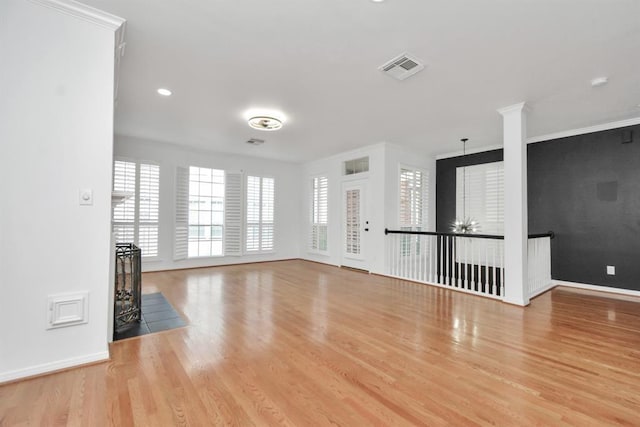 unfurnished living room featuring recessed lighting, wood finished floors, visible vents, ornamental molding, and baseboards