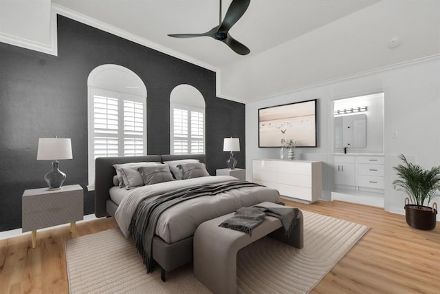 bedroom featuring ceiling fan, ornamental molding, ensuite bathroom, and light wood-type flooring