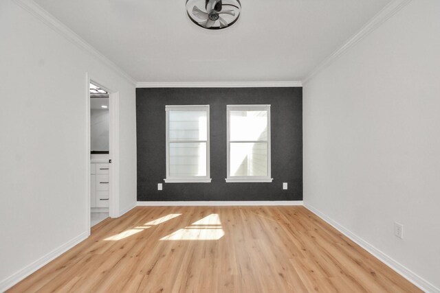 spare room featuring crown molding and light hardwood / wood-style flooring