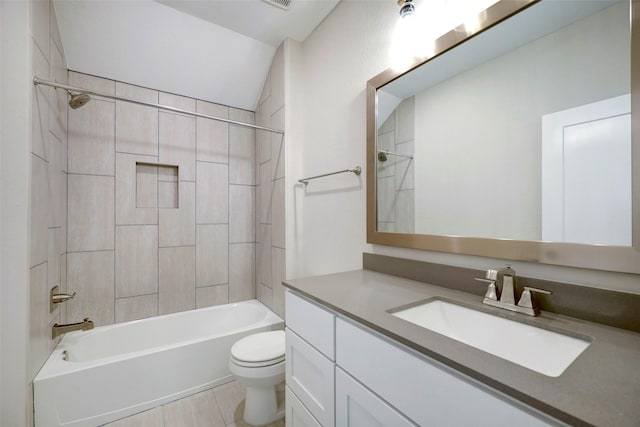 full bathroom with vanity, vaulted ceiling, tiled shower / bath combo, and toilet