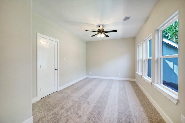 carpeted spare room with ceiling fan